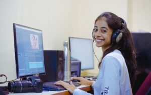 free-photo-of-a-girl-in-headphones-smiling-while-sitting-at-a-computer